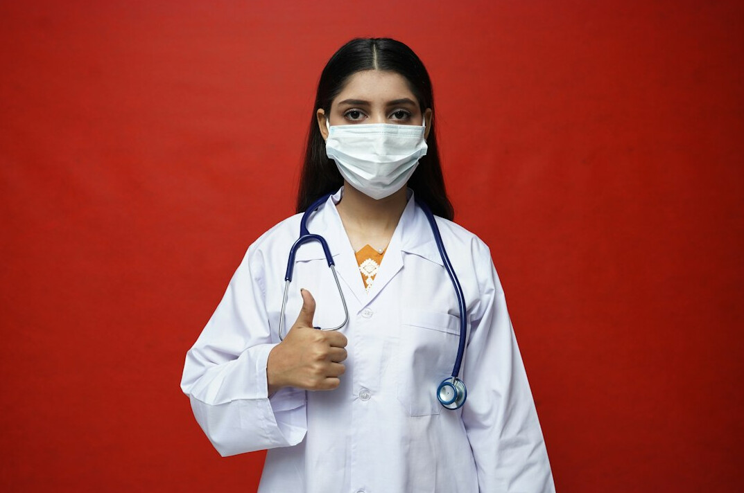 Woman doctor with dark hair in white coat smiling portrait